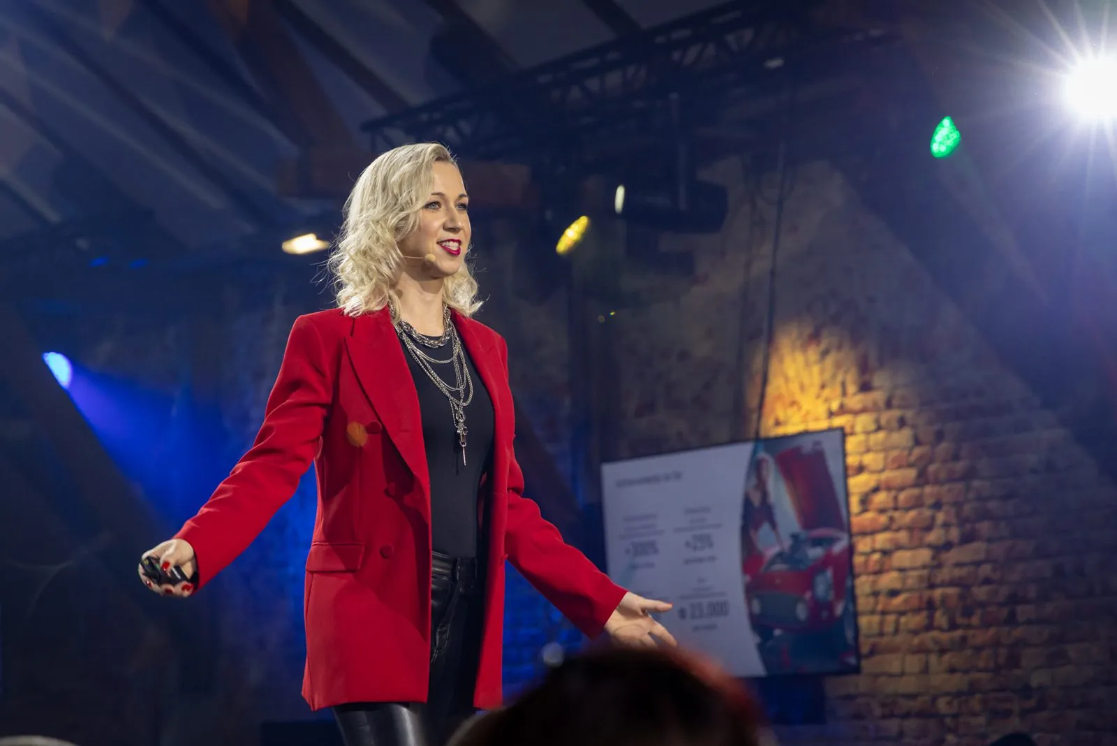 Denise Stadtegger on stage in a red blazer
