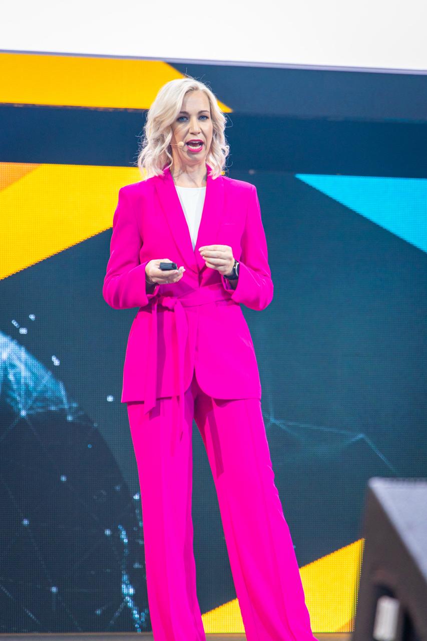 Denise Stadtegger bei einer Marketing-Keynote im pinken Anzug